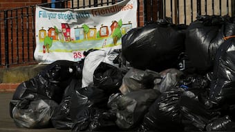 A sign reading "Fill your street with friendliness" is seen next to a large pile of rubbish on the pavement, in Stirchley, Birmingham. Reuters
