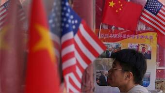 A man walks into a merchandise store displaying Chinese and United States' national flags, in Beijing. AP

