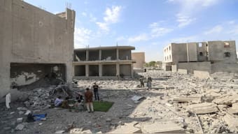 People assess the damage after strikes in Saada attributed by the Houthi rebels to the US. AFP