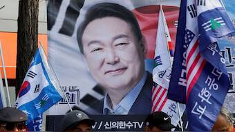 Demonstrators stand in front of a banner with the photograph of Yoon Suk Yeol as people wait for the Constitutional Court ruling on President Yoon Suk Yeol's impeachment, near his residence in Seoul, South Korea, April 4, 2025. File Image/Reuters