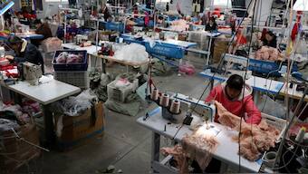 Employees work with sewing machines on the production line of a lingerie factory in Guanyun county of Lianyungang, Jiangsu province, China. File image/ Reuters