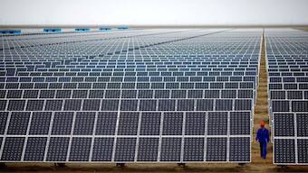 A worker inspects solar panels at a solar farm in Dunhuang, 950km (590 miles) northwest of Lanzhou, Gansu Province September 16, 2013.