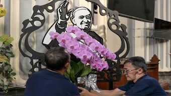 A portrait of Pope Francis (C) is seen as church officials make preparations at the Jakarta Cathedral in Jakarta, following the death of Pope Francis in the Vatican. Pope Francis died on April 21, aged 88, a day after making a much hoped-for appearance at Saint Peter's Square on Easter Sunday. AFP