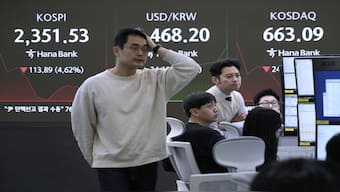 Currency traders work near a screen showing the Korea Composite Stock Price Index (KOSPI), at the foreign exchange dealing room of the KEB Hana Bank headquarters in Seoul, South Korea. AP