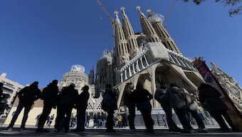 People wait in front of the Passion facade (Western side) of the Basilica and Expiatory Church of the Holy Family (Sagrada Familia) in Barcelona. The country has now ended its golden visa programme, starting today (April 3). File image/AFP