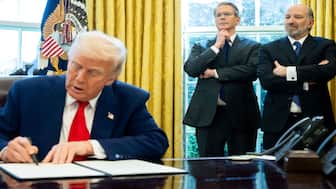 US President Donald Trump signs an executive order as Treasury Secretary Scott Bessent and Commerce Secretary Howard Lutnick look on in the Oval Office of the White House. AFP file