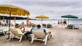 Tourists relax along Patong Beach on the southern Thai island of Phuket. Thailand's residency by investment programmes are among the best in the world as judged by Henley & Partners. File image/AFP