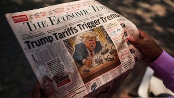 A man reads a newspaper outside the Bombay Stock Exchange (BSE) after Trump's tariff plan announcement, in Mumbai, on April 4. The levies have led to fears of global recession as a trade war looms. Reuters