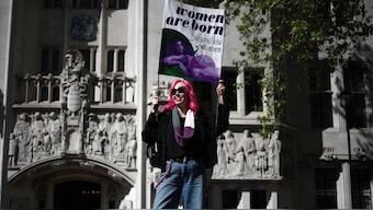 An activist holds a placard reading "Women are born, not some bloke with a form" outside the Supreme Court in London, following the court's ruling on how to define a 'woman'. Britain's Supreme Court said the legal definition of a "woman" is based on a person's sex at birth, a landmark ruling with far-reaching implications to the bitter debate over trans rights. AFP