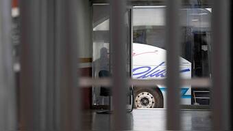 A law enforcement officer surveils a bus used to transport deportees from the U.S. to Nogales, Sonora, Mexico. Reuters
