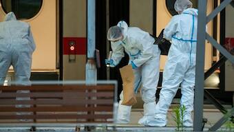 Forensic police officers investigate on the railway platform at Hamburg's main train station where at least 12 people have been injured in a knife attack. AFP