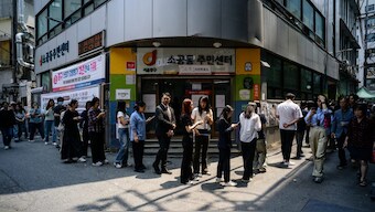 People stand in a long queue that leads to a polling station during the second day of early voting for the presidential elections in Seoul. AFP