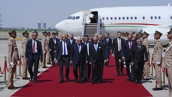 Iraqi Foreign Minister Fuad Hussein, center right, welcomes Palestinian President Mahmoud Abbas upon arrival at Baghdad International Airport ahead of the 34th Arab League summit, in Baghdad, Iraq. AP