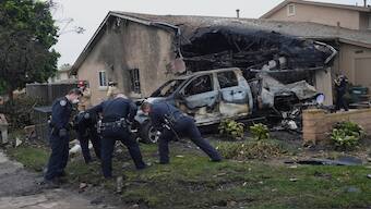 Authorities work the scene where a small plane crashed into a San Diego neighborhood, setting several homes on fire and forcing evacuations along several blocks early Thursday. AP 