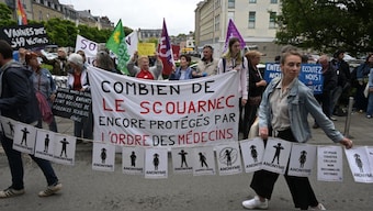 Protestors hold signs bearing the names of the victims and a banner reading 'how many Le Scouarnec are still protected by the medical board' (C) during a demonstration in support of victims at the courthouse on the sidelines of retired surgeon Joel Le Scouarnec's trial in Vannes, northwestern France, on May 28, 2025. (Photo: AFP)