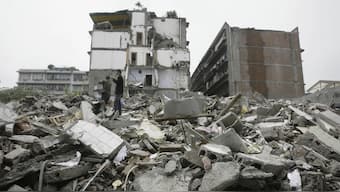 Residents try to use mobile phone to call their missing relatives as they search for survivors amongst the rubble of a collapsed building in China's Sichuan Province on May 15, 2008. File image/AP