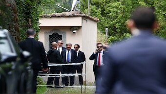 Delegation members stand with security as they arrive at the Omani embassy, where the fifth round of US-Iran talks takes place, in Rome, Italy, on Friday. Reuters