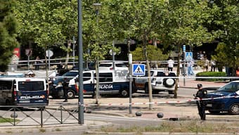 Police officers work near the body (L, behind tarp) of ex-Ukraine MP Andrey (Andriy) Portnov after he was shot dead in front of his children school in Pozuelo de Alarcon, near Madrid, on Wednesday. AP