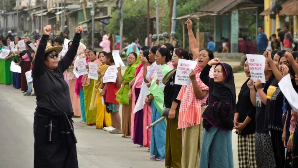 Agitators form a human chain during a protest over the alleged removal of 'Manipur' signage from a state government bus in Imphal. PTI Agitators form a human chain during a protest over the alleged removal of 'Manipur' signage from a state government bus in Imphal. PTI