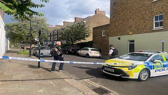 A person approaches a police officer on a cordoned-off street in north London, where a fire broke out early Monday at the home of British Prime Minister Keir Starmer. (Photo: Reuters)