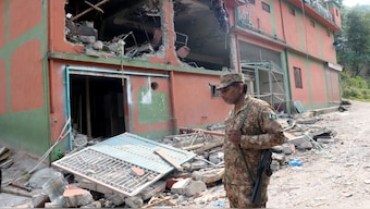 A Pakistan Army soldier stands in front of damaged building after it was hit by an Indian strike in Muzaffarabad, in PoK on May 7. Reuters