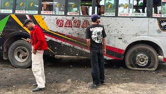 Local residents stand beside a damaged bus in the Indian-run town of Poonch on May 8, 2025. AFP