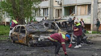 Municipal workers clean up around burnt cars in the residential area following Russia's drone attack in Kyiv, Ukraine, Sunday, May 4, 2025. (AP Photo)