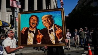 (sensitive material. this image may offend or disturb) Supporters of US President Donald Trump carry a picture depicting Tesla CEO Elon Musk and US President Donald Trump during a May Day rally in New York City, US, May 1, 2025. File Image/Reuters