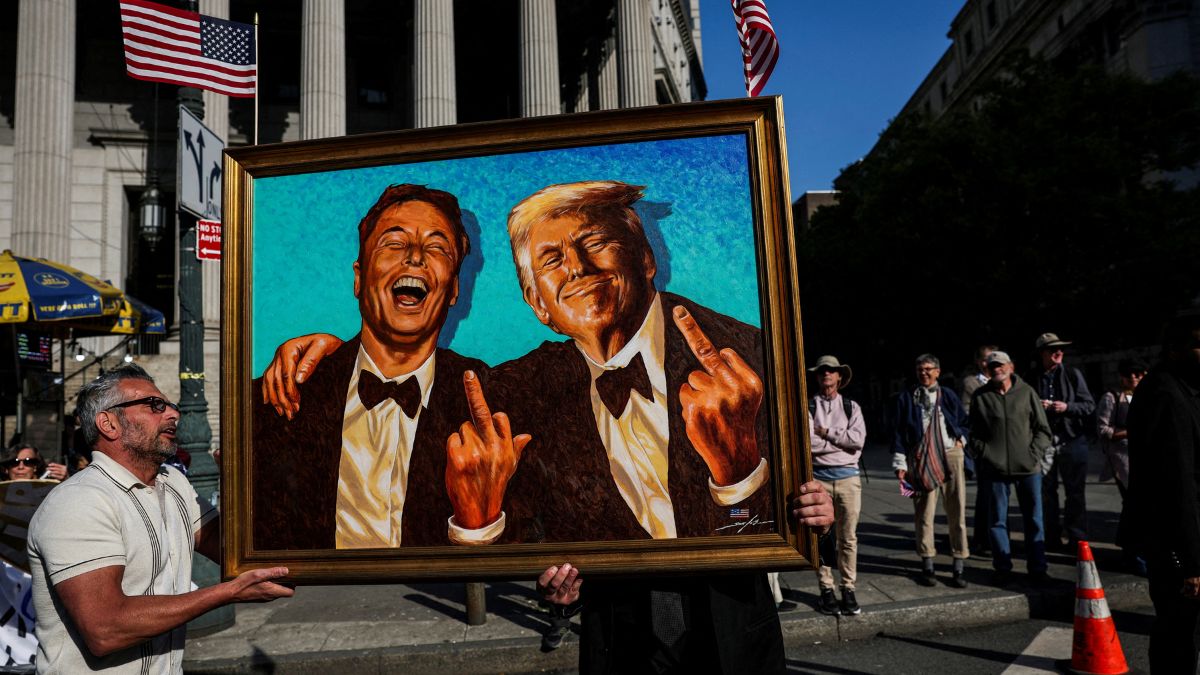 (sensitive material. this image may offend or disturb) Supporters of US President Donald Trump carry a picture depicting Tesla CEO Elon Musk and US President Donald Trump during a May Day rally in New York City, US, May 1, 2025. File Image/Reuters (sensitive material. this image may offend or disturb) Supporters of US President Donald Trump carry a picture depicting Tesla CEO Elon Musk and US President Donald Trump during a May Day rally in New York City, US, May 1, 2025. File Image/Reuters