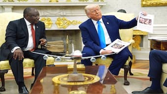 US President Donald Trump shows documents claiming genocide against Afrikaners to South Africa's President Cyril Ramaphosa in the Oval Office on Wednesday. AP