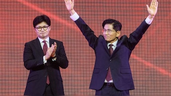 Former labour minister Kim Moon-soo (R) celebrates next to ex-party chief Han Dong-hoon after winning the final race to choose South Korea's conservative People Power Party's (PPP) candidate for the upcoming presidential election. AFP