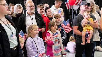 The first group of Afrikaners from South Africa to arrive for resettlement listen to remarks from US Deputy Secretary of State Christopher Landau and US Deputy Secretary of Homeland Security Troy Edgar (both out of frame), after they arrived at Washington Dulles International Airport in Dulles, Virginia, on May 12, 2025. AFP