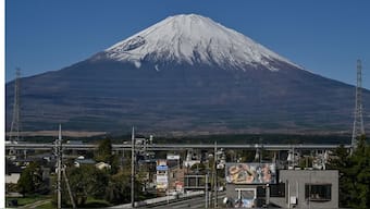 Mount Fuji pictured in the background as traffic travels down a road in the city of Gotemba, Shizuoka prefecture, some 100 kms southwest of Tokyo. AFP