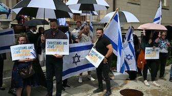 People hold signs and Israeli national flags in a sign of support outside the Capital Jewish Museum following a shooting that left two people dead, in Washington, DC, on May 22, 2025. AFP