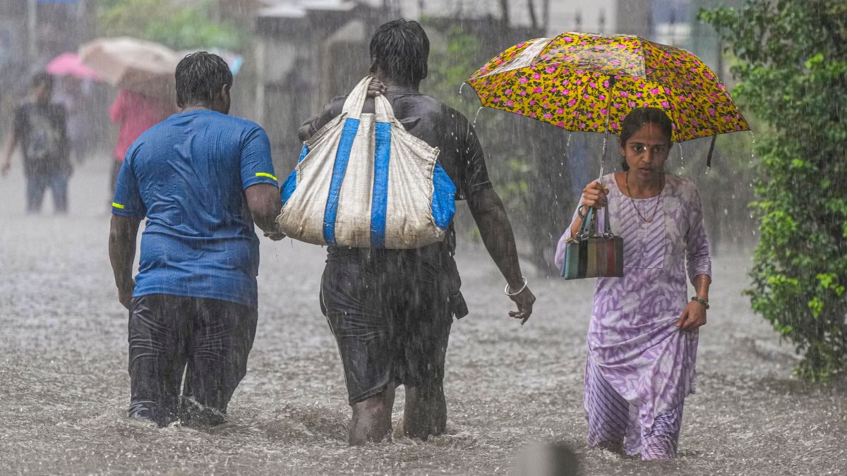 People make their way through a waterlogged road near Gandhi Market at Matunga after heavy rains, in Mumbai, May 26, 2025. PTI People make their way through a waterlogged road near Gandhi Market at Matunga after heavy rains, in Mumbai, May 26, 2025. PTI