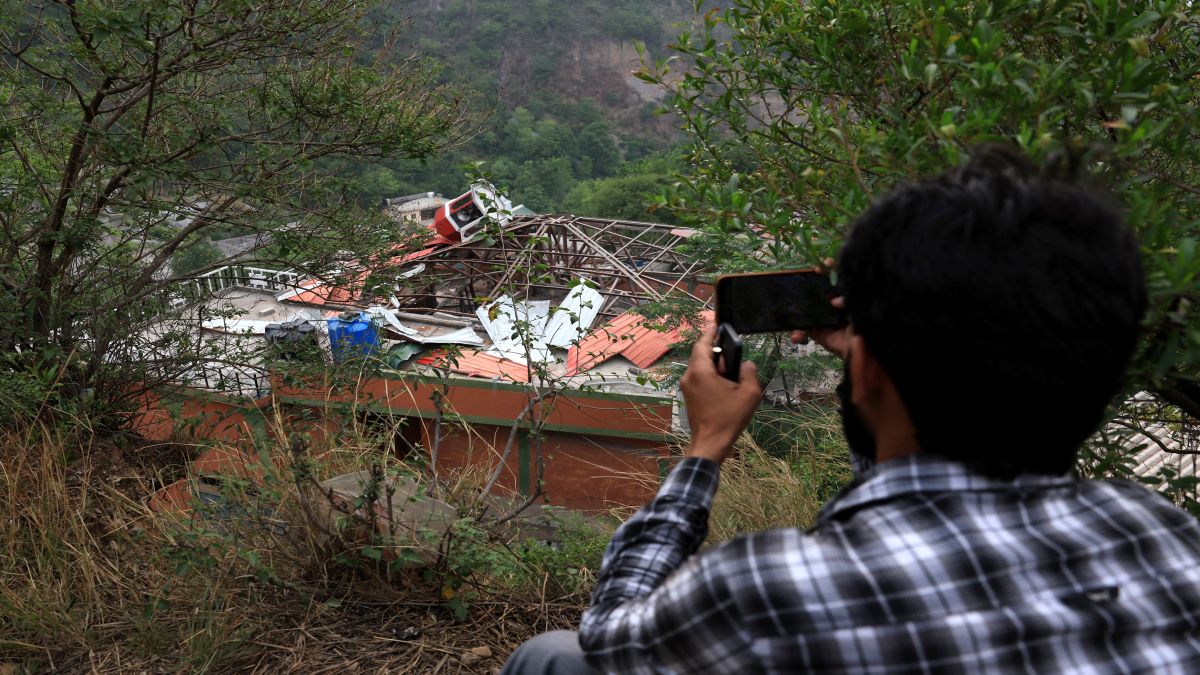 A person snaps a photo of a building fallen after it was hit by an Indian strike in Muzaffarabad. Reuters A person snaps a photo of a building fallen after it was hit by an Indian strike in Muzaffarabad. Reuters