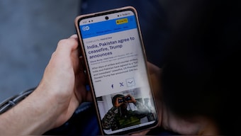 A man reads news on his mobile phone after the ceasefire announcement between India and Pakistan, in Srinagar May 10. The two sides have agreed to a 'conditional' truce after four days of escalation. Reuters