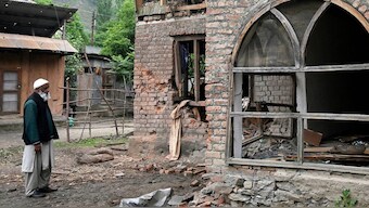 A local resident inspects his house that was damaged by Pakistani artillery shelling in Uri. Source: AFP
