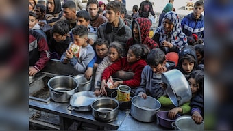 Palestinian people with empty bowls wait for food at a donation point in Rafah. The widespread hunger and malnutrition in Gaza is catastrophic, UN has said. (Photo: NPR)