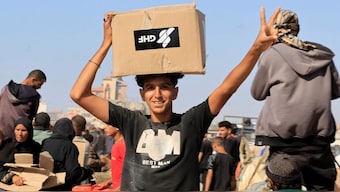 A man carries a box as Palestinians seeking aid gather near an aid distribution site run by the US-backed Gaza Humanitarian Foundation, in Rafah, in the southern Gaza Strip. Reuters