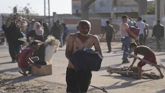 Palestinians carry boxes containing food and humanitarian aid packages delivered by the Gaza Humanitarian Foundation, in Rafah. AP