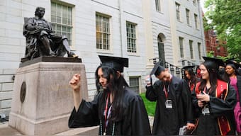 Students walk near the statue of John Harvard on the day of the 374th Commencement exercises at Harvard University in Cambridge, Massachusetts. Indians are among largest groups of international graduate students in US. Reuters