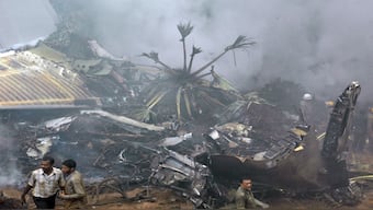 Rescue personnel are seen near the smouldering wreckage of an Air India Boeing 737-800 aircraft which crashed upon landing in Mangalore on May 22, 2010. File image/AFP