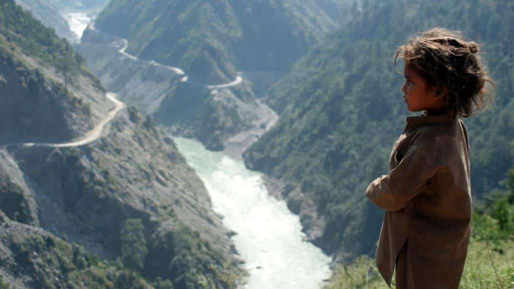 A child stands near Chenab River with the Baglihar hydroelectric project in the background, about 155 km northwest of Jammu. File photo/Reuters