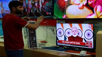 A salesman watches Prime Minister Narendra Modi addressing the nation on a TV screen inside a shop in the old quarters of Delhi. In his address, PM Modi hailed the military forces for Operation Sindoor, stating that this would be the new normal against terrorism. Reuters