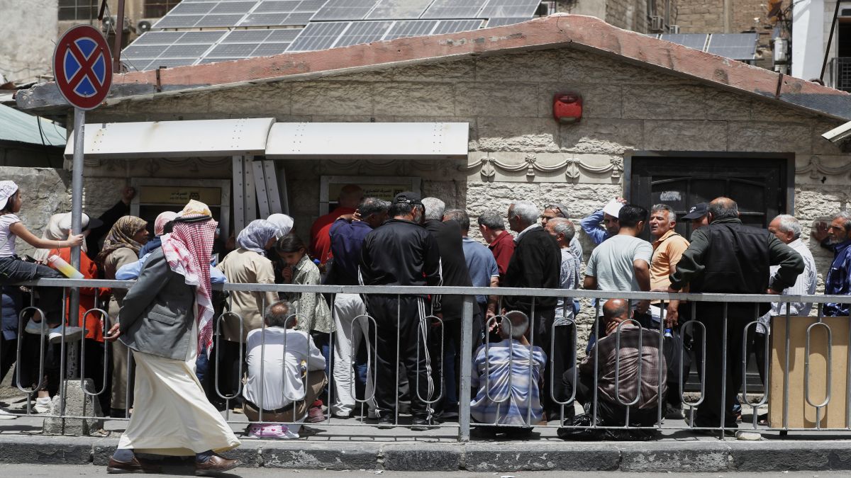 Syrians line up to retrieve money from an ATM in Damascus, Syria. AP Syrians line up to retrieve money from an ATM in Damascus, Syria. AP