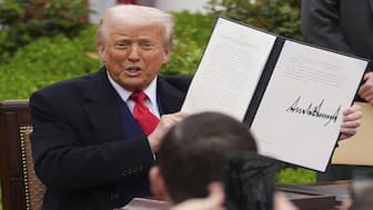 President Donald Trump holds a signed executive order during an event to announce new tariffs in the Rose Garden of the White House on April 2. File image/AP