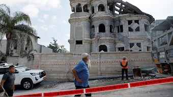 A man walks after missiles fired from Iran impacted on a residential building in northern Israel in Tamra. Reuters