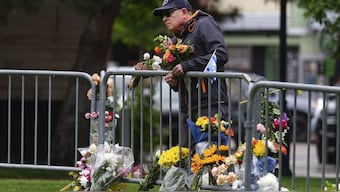 A man affixes a bouquet of flowers to a makeshift memorial for victims of an attack outside of the Boulder County, Colo., courthouse, in Boulder, Colo. AP