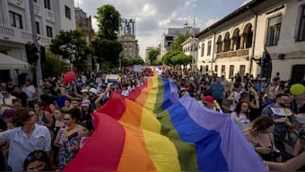 People hold a rainbow flag banner during the gay pride parade in Bucharest, Romania. AP